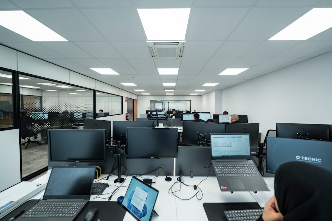 Modern kantoor met werknemers aan computerwerkplekken, de omgeving waarin contextbewuste werkplekken in opkomst zijn