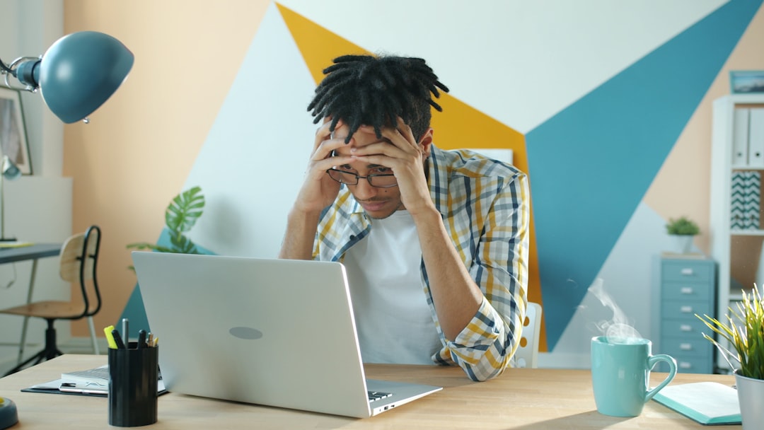 Stressed employee looking at a laptop screen, illustrating the low intranet adoption many companies quietly struggle with