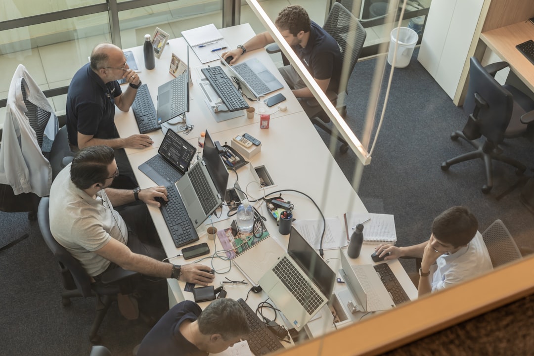Team aan het werk aan bureaus in een modern kantoor, de omgeving waar AI-agents voor samenwerking steeds vaker worden gebruikt